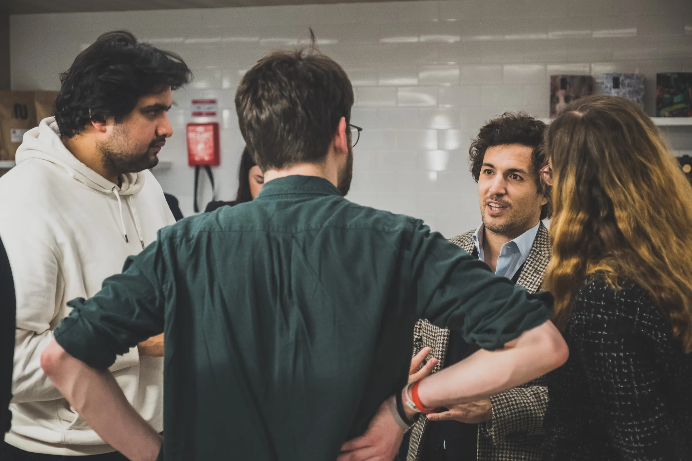 FOV Ventures First Birthday Party - Small group conversation, tiled backdrop