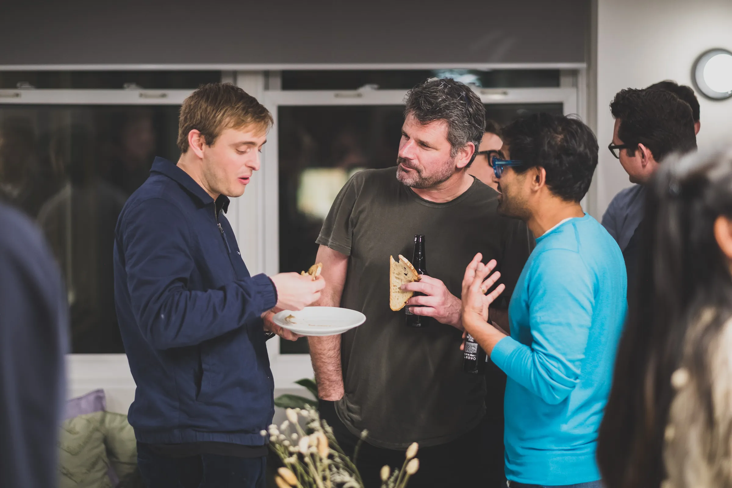 FOV Ventures First Birthday Party - Guests chatting over drinks and bread