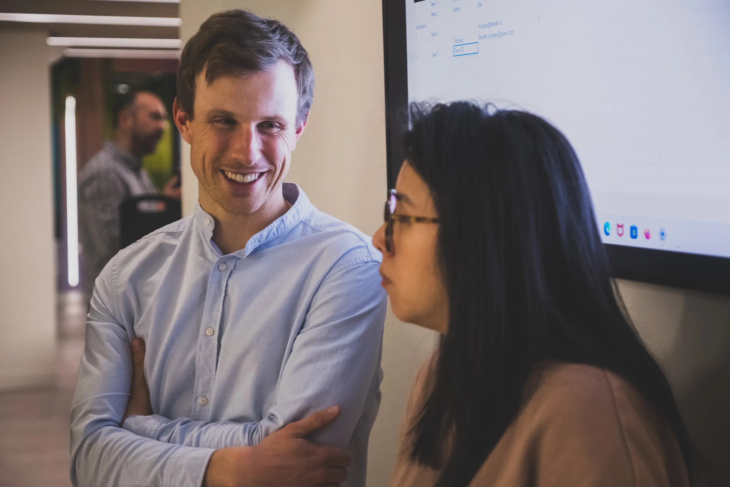 FOV Ventures First Birthday Party - Guest smiling mid-conversation near a screen