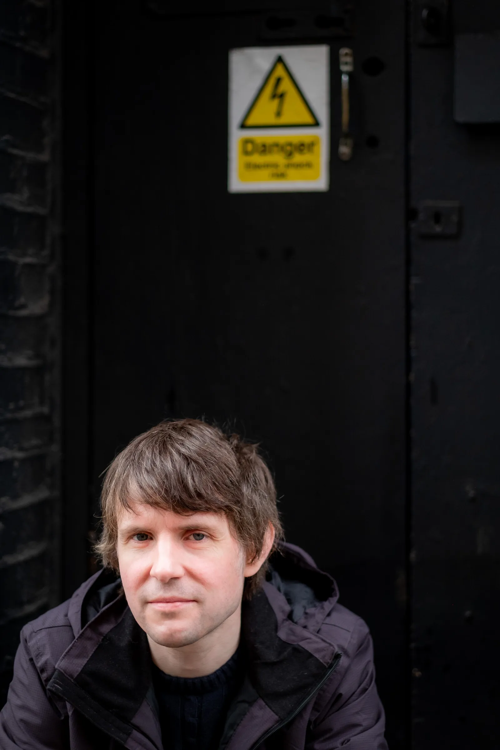 Martin Bryant Personal Branding Headshots - Portrait against industrial door, danger sign detail