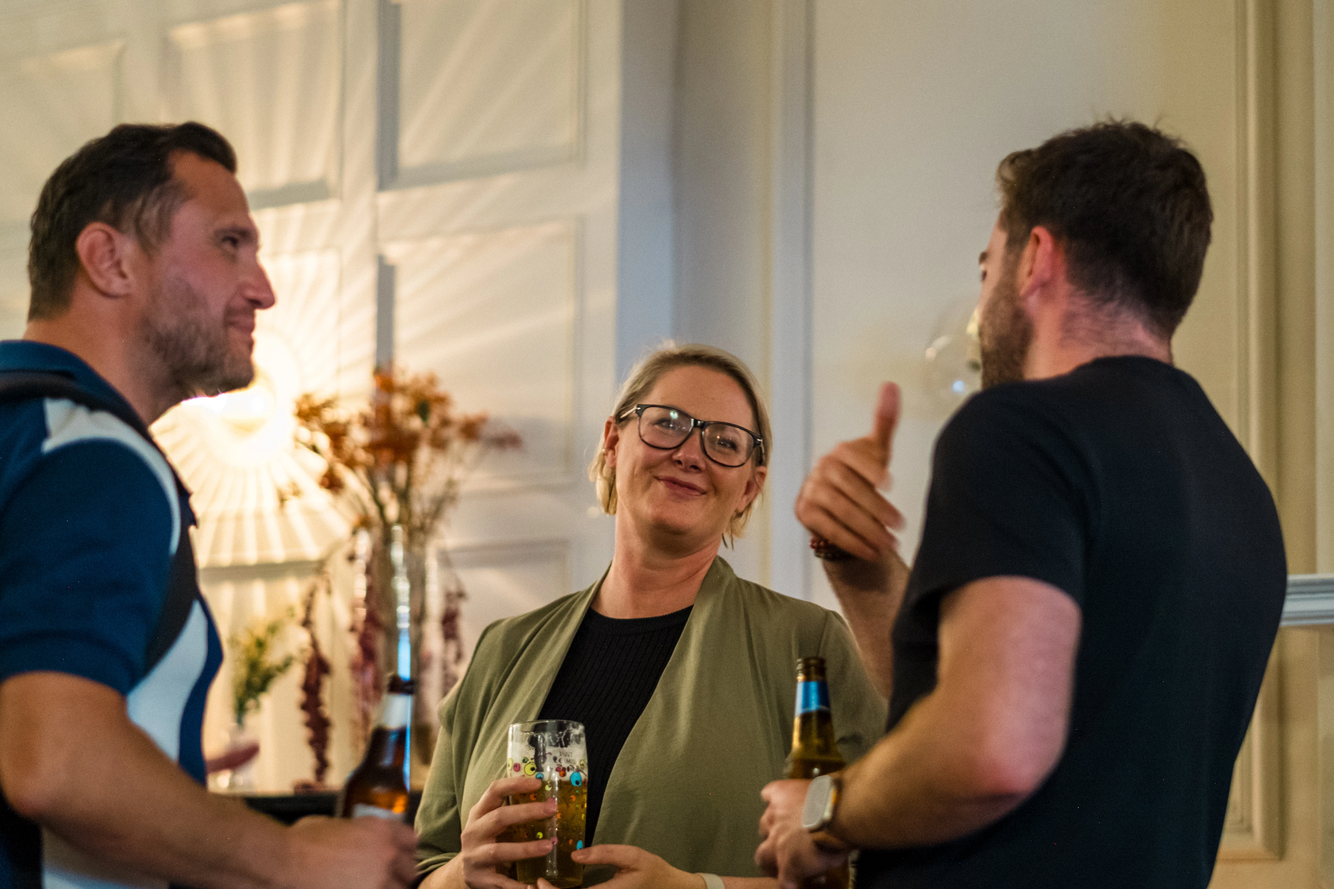Planet A Ventures Meetup London - Three guests chatting beside a vase of dried flowers